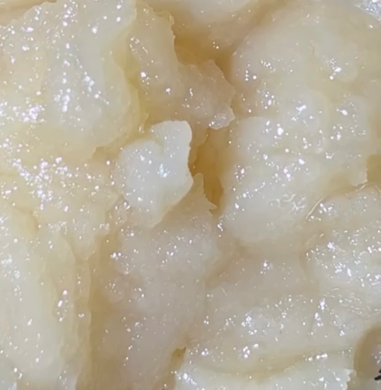 Fresh-pressed live rosin oozing from parchment between low-temp plates
